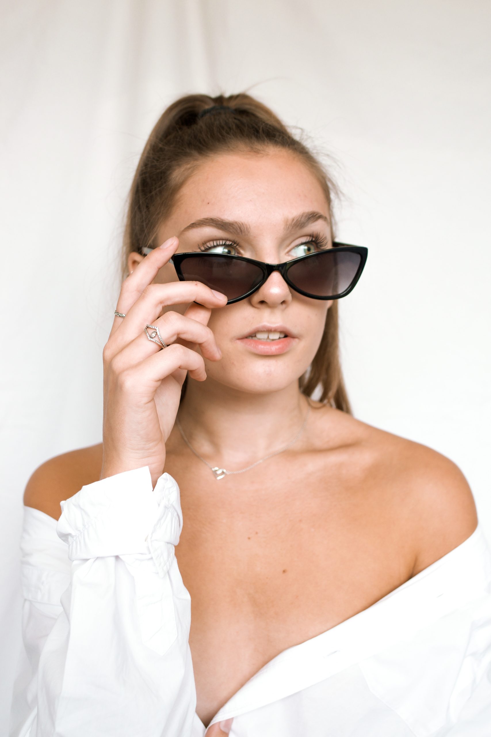 woman in white off shoulder top wearing black sunglasses